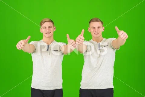 The two handsome twin thumb up on the green background Stock Photos