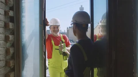 Two handymen having break drinking beer on balcony Stock Footage 133638782