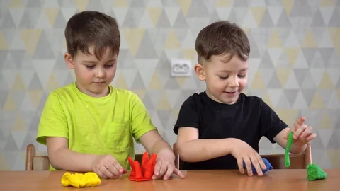 Two Happy boy playing with plasticine. Stock Footage 128973346