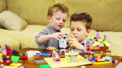 Two happy boys play with robot and with tinker toys, slow motion Stock Footage 276364984