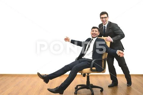 The two happy businessmen ride on the chair on the white wall background Stock Photos