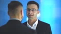 The two happy businessmen talk on the blue background. slow motion 4k or 4k+ Resolution