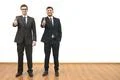 The two happy businessmen thumb up on the white wall background Photo