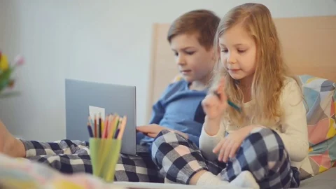 Two happy children having fun with laptop in bed Stock Footage 72522681