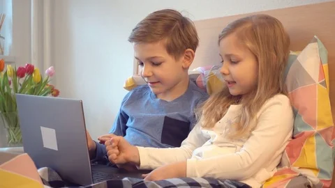 Two happy children having fun with laptop in bed Stock Footage 72533640