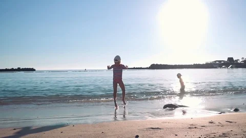 Two happy children playing in the sea near the sandy beach. Bright sunny day Stock Footage 101752823