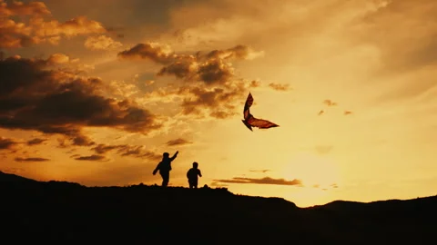Two happy children run at sunset and fly a kite. Stock Footage 281042380