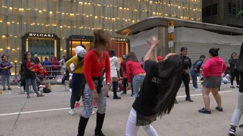 Two happy Chinese women dancing with a crowd on the street in a big city 動画素材 146590153