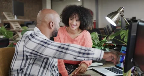 Two happy diverse creative colleagues in discussion at computer in casual Stock Footage 344103675