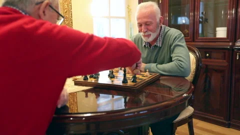 Two happy elderly friends in nursing home playing chess Stock Footage 317879258