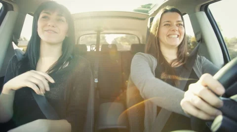 Two happy female friends driving car excited about going in vacation Stock Footage