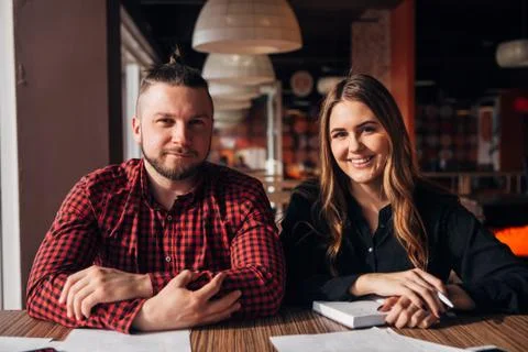 Two happy freelancer smiling at camera in cafe Stock Photos