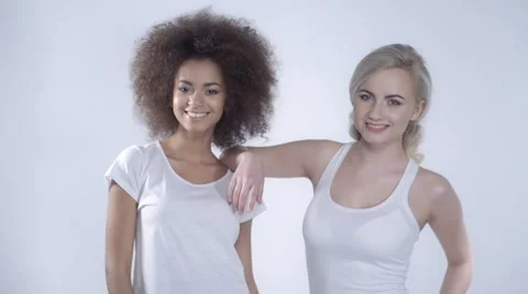 Two happy girlfriends posing on white background 動画素材 58904051