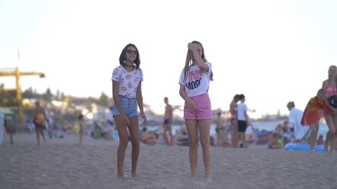Two happy girls are bouncing up on the beach near the sea Video stock 83105866