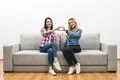 The two happy girls show the heart symbol on the white wall background Photo