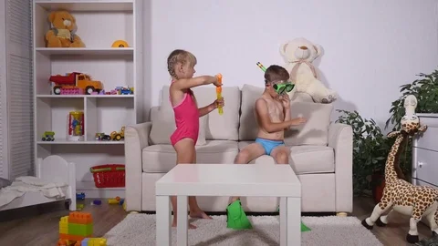 Two happy kids in diving mask sitting together in sofa Stock Footage
