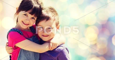 Two Happy Kids Hugging Over Blue Lights Background