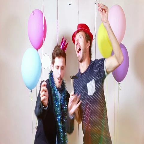 Two happy men dancing with props in photo booth Stock Footage 69302260