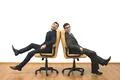 The two happy men sit on chairs on the white wall background Photo