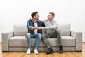The two happy men on the sofa gesture on the white wall background Photo