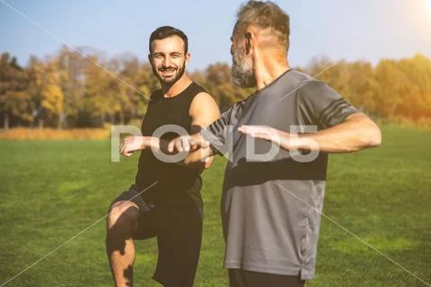 The two happy men stretching outdoor on the sunny background Stock Photos