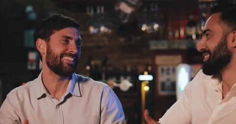 Two happy old friends drinking draft beer and talking in the sport bar. Friends Stock Footage 109479014
