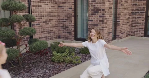Two happy sisters running to their smiling mom feeling joyful after good day Stock Footage 219022121