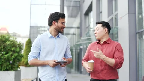 Two happy smiling businessmen engaging in discussion while walking outside moder Stock Footage 302893752
