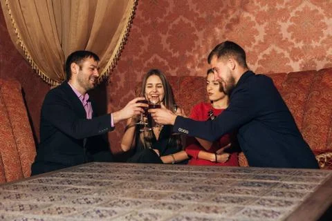 Two happy smiling young couples with champagne at celebration Stock Photos