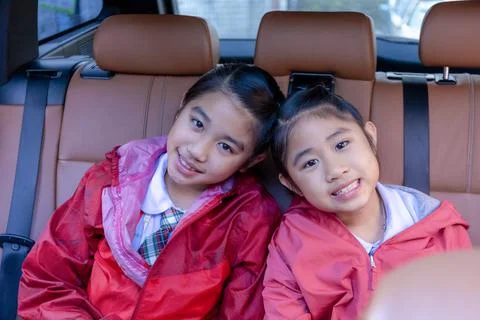 Two happy students smiling while enjoying road trip in car. Sisters smiling a Stock Photos