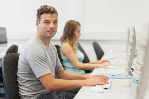 Two happy students working on computer individually Stock-Fotos
