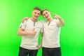 The two happy twin brother gesture on the green background Photo