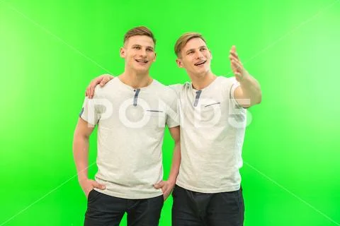 The two happy twin brother gesture on the green background Stock Photos