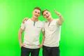 The two happy twin brother gesture on the green background Photo