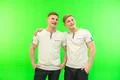 The two happy twin brother stand on the green background Photo