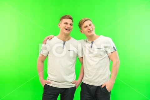 The two happy twin brother stand on the green background Stock Photos