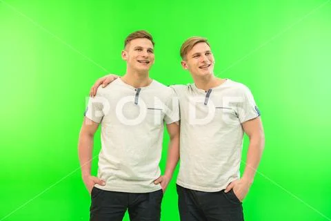 The two happy twin brother stand on the green background Stock Photos