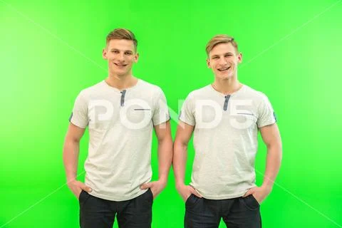 The two happy twin brother stand on the green background Stock Photos
