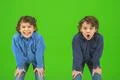 The two happy twin kids gesture on the green background Photo