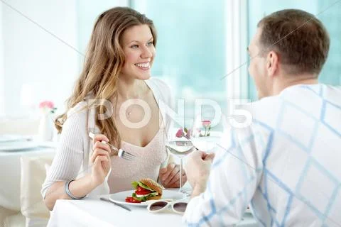 Two happy valentines sitting in cafe and enjoying each other Stock Photos