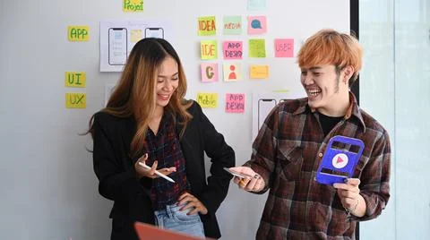 Two happy web designers presenting and testing mobile app interface design on Stockfoto's