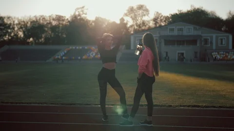 Two happy women drinking vegetable smoothie after fitness running workout on Stock Footage 104371306