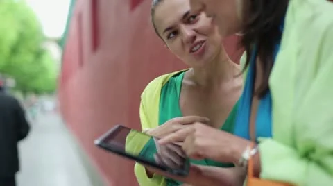 Two happy women with tablet computer standing on the street, steadycam shot Stock Footage 11241093
