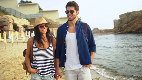 Two happy young people walking on the beach and enjoying good summer day Stock Footage 73815093