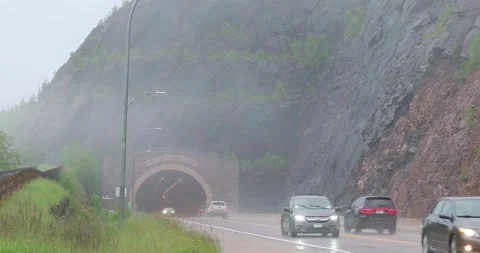 TWO HARBORS, MN - 18 JUN 2024: Traffic at a tunnel on a rainy day Stock Footage 288059281