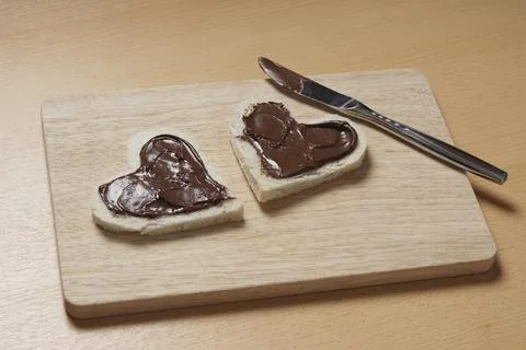 Two heart shaped bread slices with chocolate spread for Valentine#39;s day Stock Photos