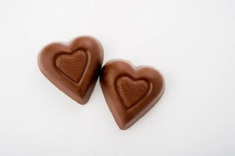 Two heart shaped chocolates Stock Photos