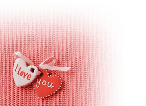 Two heart-shaped cookie making the I love you inscription on a red background Foto stock