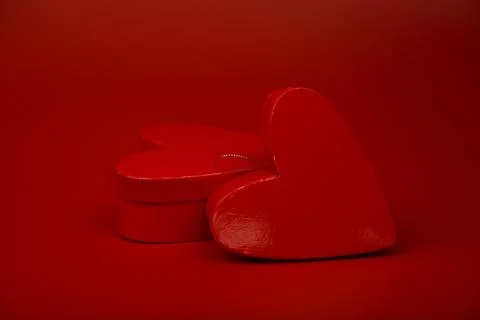 Two heart shaped gift boxes on red background Stock Photos