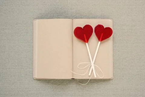 Two heart-shaped lollipops on an old diary Stock Photos